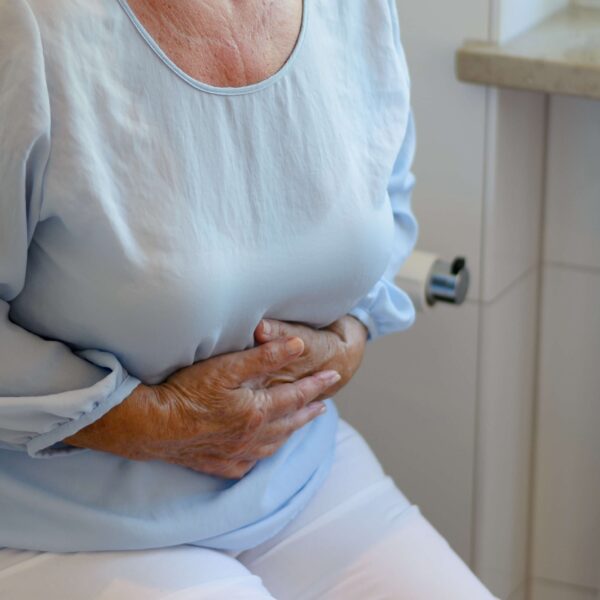 A woman holding her stomach due to constipation