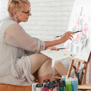 An older women in menopause painting a picture