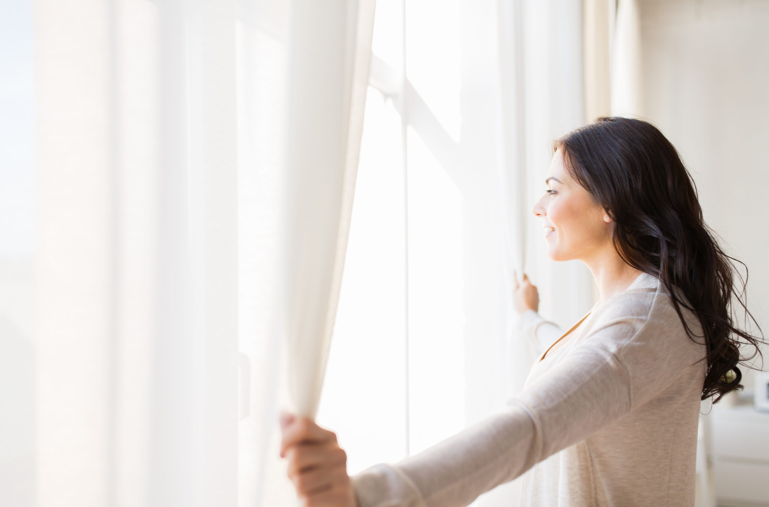 people and hope concept - close up of happy woman opening window curtains