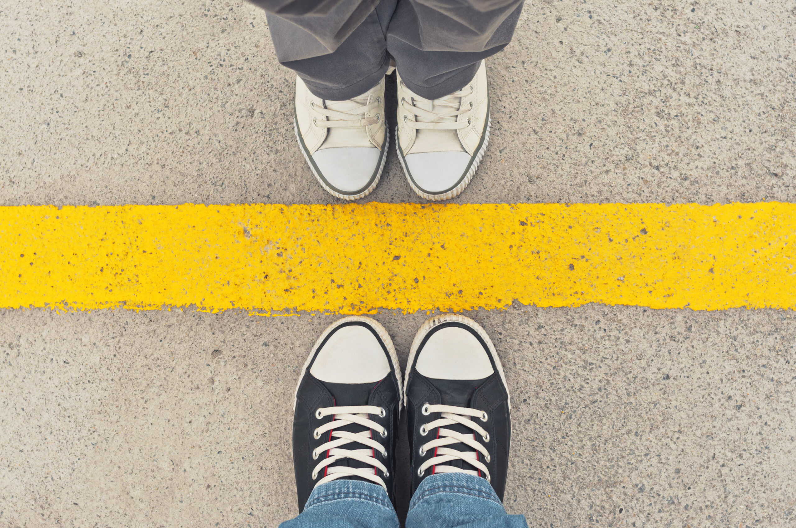 Sneakers from above. Male and female feet in sneakers from above, standing at dividing line.