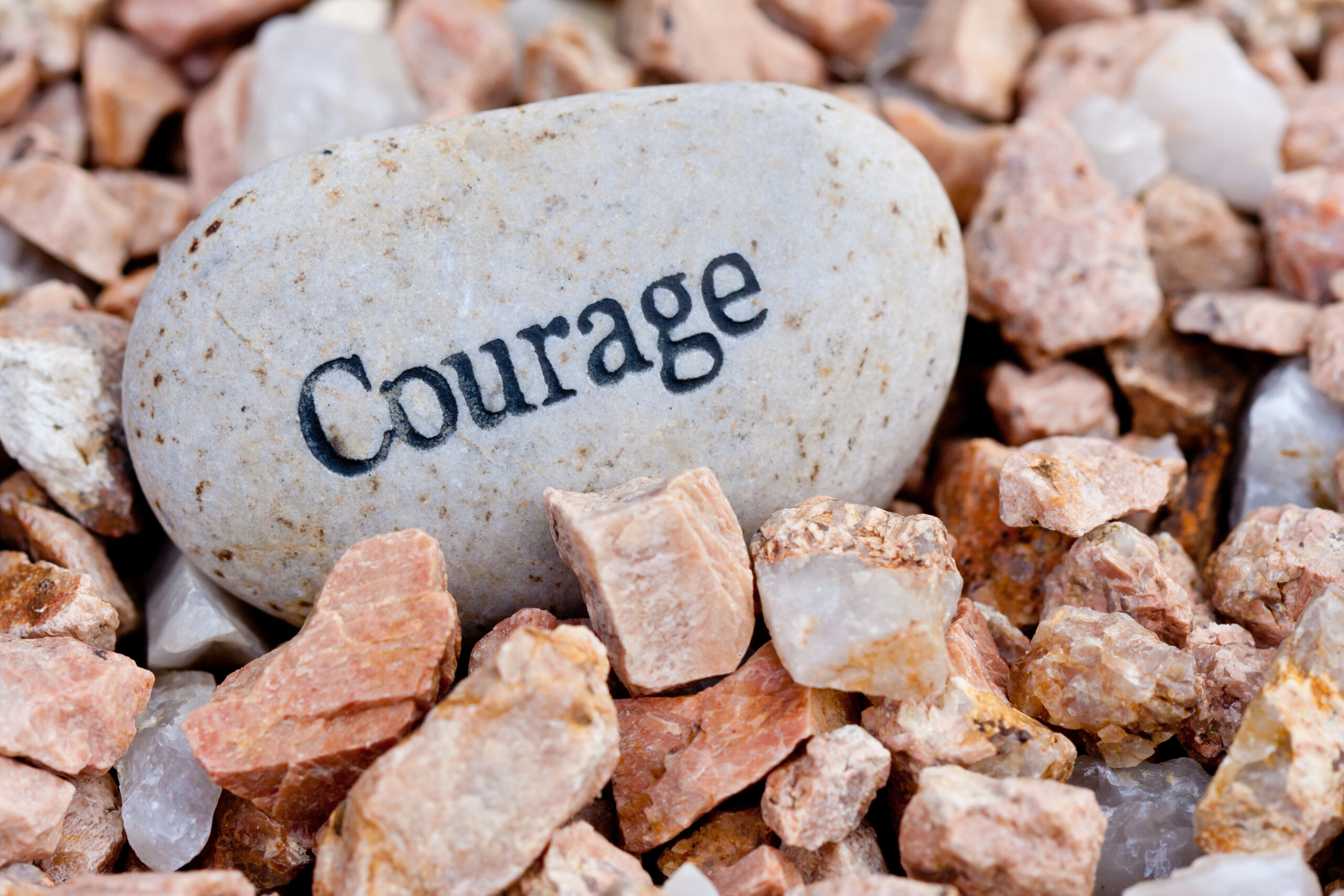 close up of 'courage' stone on textured stone background