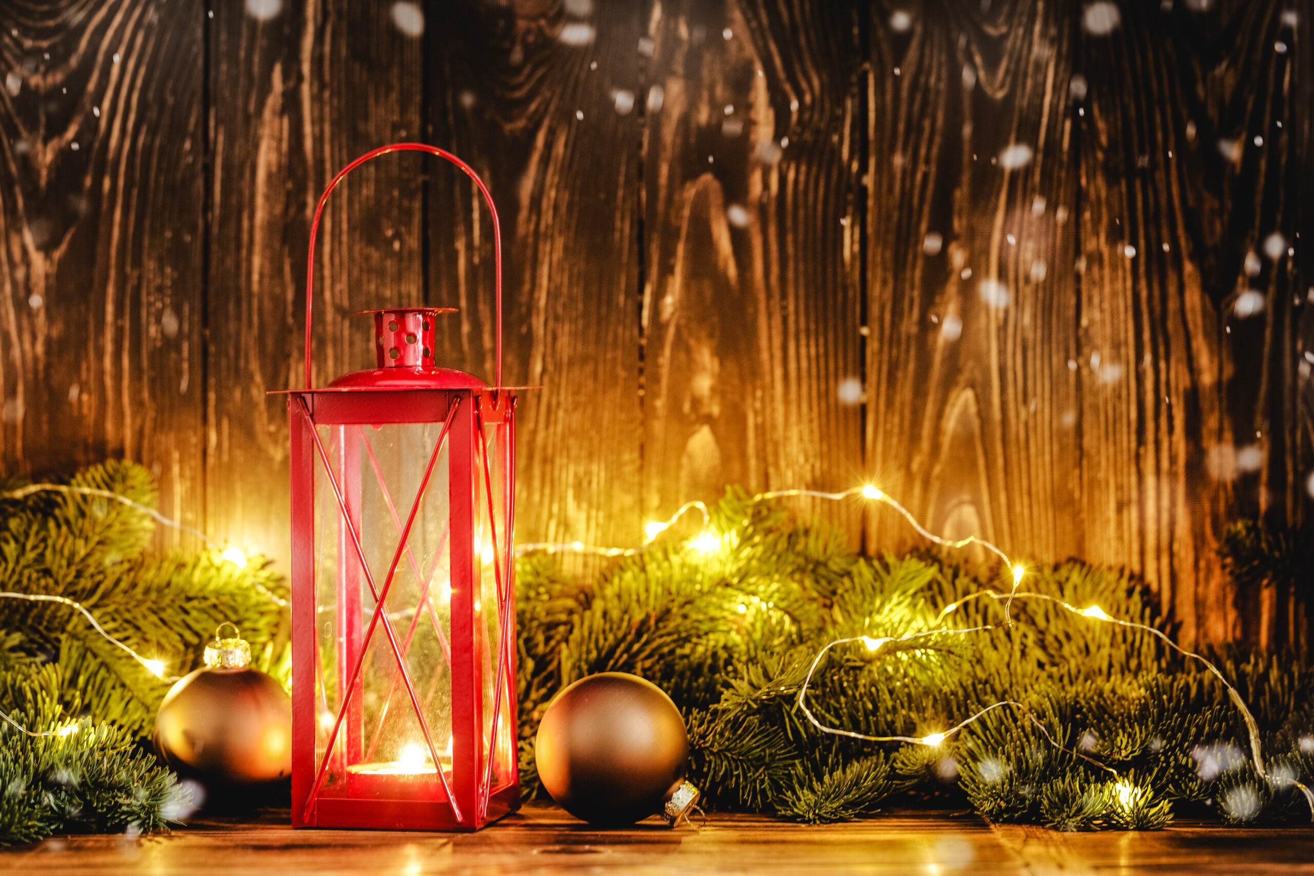 Christmas candle lantern with christmas deco on wooden background. Festive christmas concept with copy space.